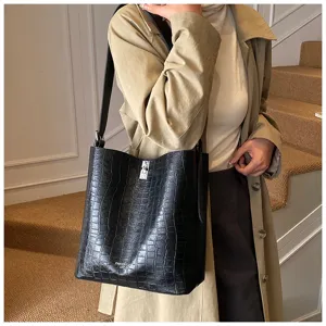 Détail du sac cabas noir croco montrant la texture luxueuse et le fermoir en métal.