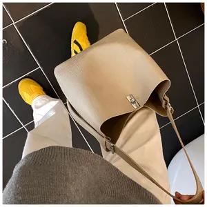 Vue détaillée d'un sac porté épaule beige élégant effet croco avec fermoir en métal.