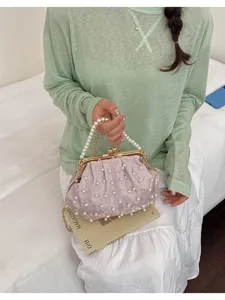 Detailaufnahme einer eleganten Perlen-Abendtasche mit goldenem Kuss-Verschluss und Kette.