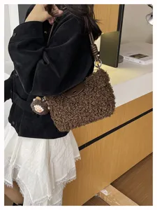 Trendy brown shearling crossbody bag for women, fuzzy shoulder handbag with cute plush pendant.