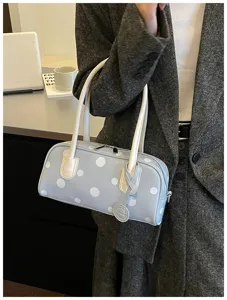 Detailansicht der stilvollen Pünktchen Bowlingtasche mit weißen Henkeln im Alltag.