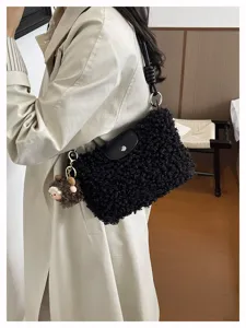 Stylish black shearling shoulder bag detail, elegant design with plush keychain and metal ring.