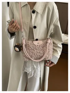 Detailed view of women faux shearling crossbody bag, fluffy plush shoulder bag with pendant.