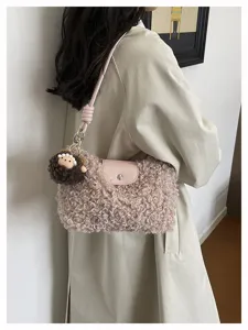 Detail view of stylish plush shoulder bag with fluffy charm, perfect for autumn and winter.