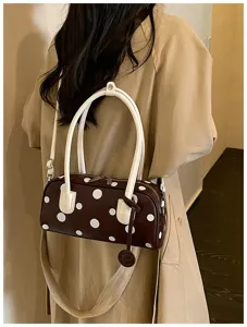 Nahaufnahme Detail der braunen gepunkteten Bowlingtasche auf der Schulter, eleganter Look.