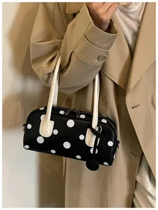 Nahaufnahme Detailansicht einer eleganten schwarz-weißen Pünktchen Bowlingtasche mit Griffen.