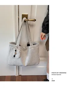 Gedetailleerd overzicht van casual gestreepte canvas tote tas met zakje, grote capaciteit.