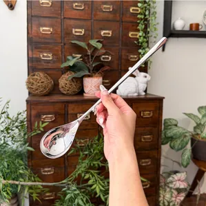 Stainless steel long handle spoon detail view, elegant design, perfect for coffee and desserts.