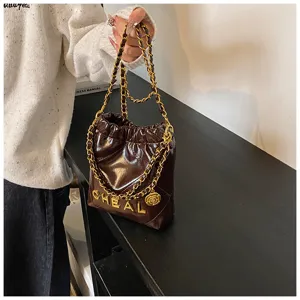 Vista dettagliata della borsa a tracolla trapuntata marrone con design a secchiello.
