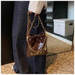 Primo piano dettagliato della borsa a tracolla trapuntata marrone scuro con catena.