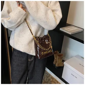 Elegante borsa a tracolla trapuntata in vernice marrone con pratica chiusura a coulisse.