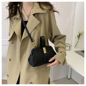 Primo piano dettagliato della elegante borsa a mano in pelle nera indossata dalla modella.