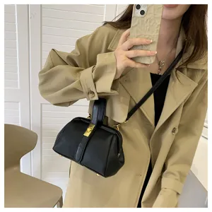 Vista di dettaglio di un'elegante borsa nera con trama litchi e dettagli metallici dorati.