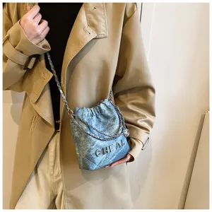 Borsa a tracolla trapuntata in denim da donna, mini borsa secchiello con lettere in metallo.