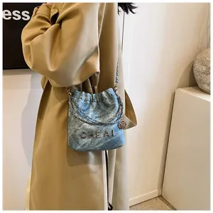 Vista dettagliata della borsa a tracolla in denim trapuntato con catena, borsa mini chic.