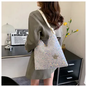 Detailed view of fashionable women sequin shoulder hobo bag with star charm in lifestyle scene.