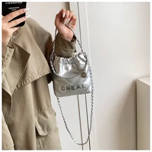 Primo piano della borsa a tracolla trapuntata argentata metallizzata, con dettagli di texture.