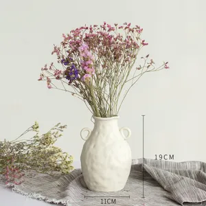 Détail de vase en céramique nordique blanche avec composition florale montrant hauteur 19cm.