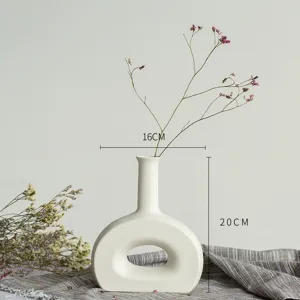 Détail de vase en céramique blanche style nordique montrant les dimensions et décoration florale.