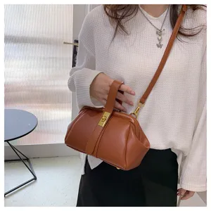 Primo piano della borsa a mano in pelle marrone con trama fine e dettaglio della chiusura.