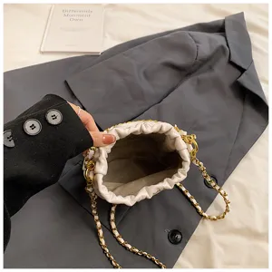 Vista dettagliata dell'interno della borsa a catena trapuntata bianca con coulisse.