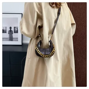 Detailansicht der retro öl-wachs leder mini halbmond umhängetasche mit klobiger goldkette.