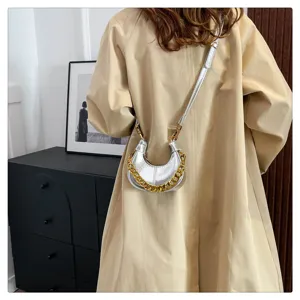 Silberne Mini-Umhängetasche Detail, Halbmondform mit goldenem Kettenakzent für Damen.