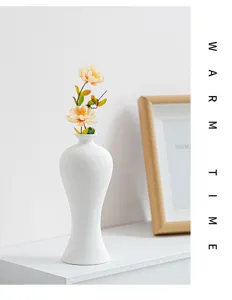 White ceramic vase detail with artificial flower decoration, minimalist home decor style showcase.