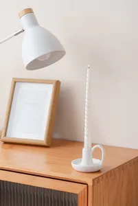 Bougeoir en céramique blanche minimaliste avec poignée et bougie pour décoration de table.
