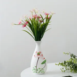 Vase en céramique blanche avec lotus peint à la main et bouquet de fleurs artificielles.