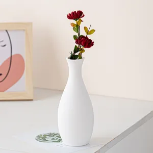 White ceramic vase with artificial red flowers home decor minimalist tabletop centerpiece display