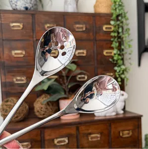 Stainless steel spoons detail showing polished surface and cute cat paw cutout design.