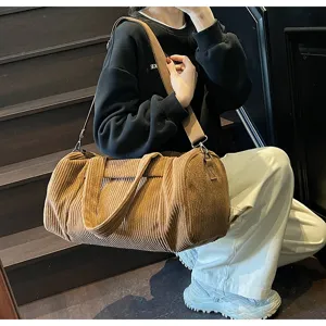 Dettaglio borsa a tracolla cilindrica in velluto a coste marrone, grande capacità borsa da viaggio.