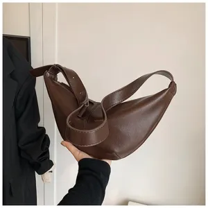 Gros plan du sac croissant en cuir synthétique marron mettant en valeur sa forme incurvée.