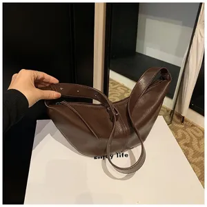 Gros plan sur le sac hobo en cuir PU marron, design rétro et détail de sangle élégante.