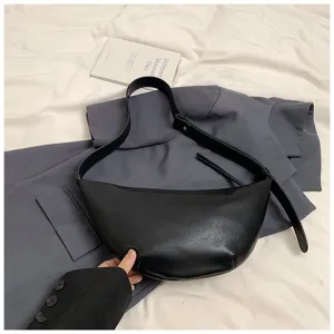 Vue détaillée du sac croissant en cuir noir montrant une texture fine et une lanière.