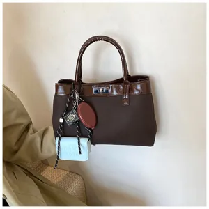 Brown women's handbag stylish tote bag casual shoulder bag with metal lock and cute charms detail.