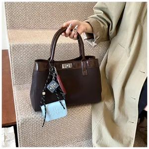Chic brown tote handbag with patent leather trim, twist lock and stylish charms for women