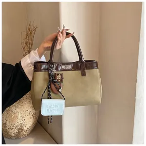 Chic minimalist brown and khaki two-tone women's handbag with stylish mini charm accessories.