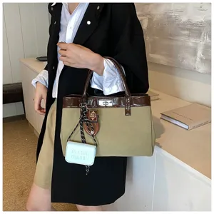 Detailed view of the stylish contrast canvas handbag with cute mini pendants and comfortable handle.
