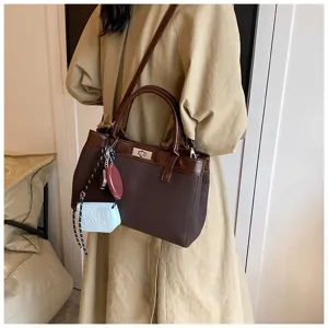 Detailed view of women fashion brown tote handbag, minimalist design with pendant accessory.