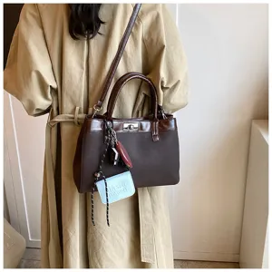 Close-up detail of the stylish brown tote bag featuring contrast trim and a chic metal lock.