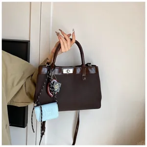 Brown canvas casual crossbody handbag with small coin purse and bible pendant detail.