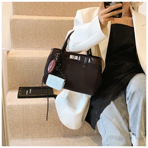 Detail shot of the chic brown handbag with cute charms on stairs, elegant aesthetic.