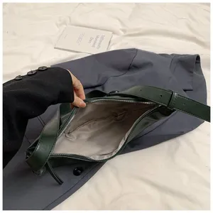 Gros plan détaillé de l'intérieur du sac hobo vert foncé, montrant la fermeture éclair.