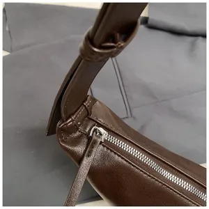 Vue détaillée d'un élégant sac à épaule marron foncé en cuir avec fermeture éclair métallique