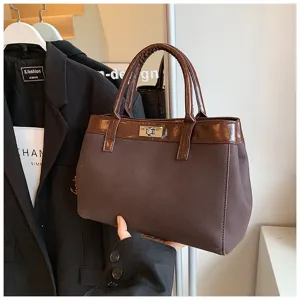 Brown women handbag detail, elegant autumn design with metal lock and sturdy handles for daily use.