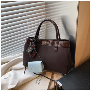 Brown tote handbag with mini pouch charm, minimalist retro style shoulder bag detail view.