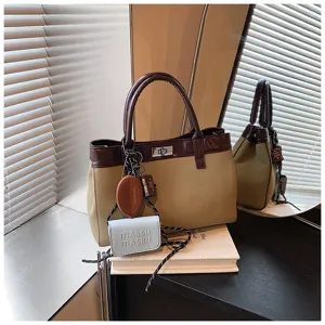 Detailed shot of two-tone fashion top handle bag with chic charms and book prop in interior.