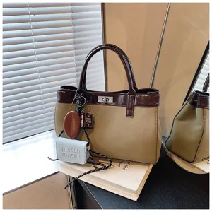 Detailed view of trendy Maillard style retro colorblock women handbag with cute charms and shoulder strap.